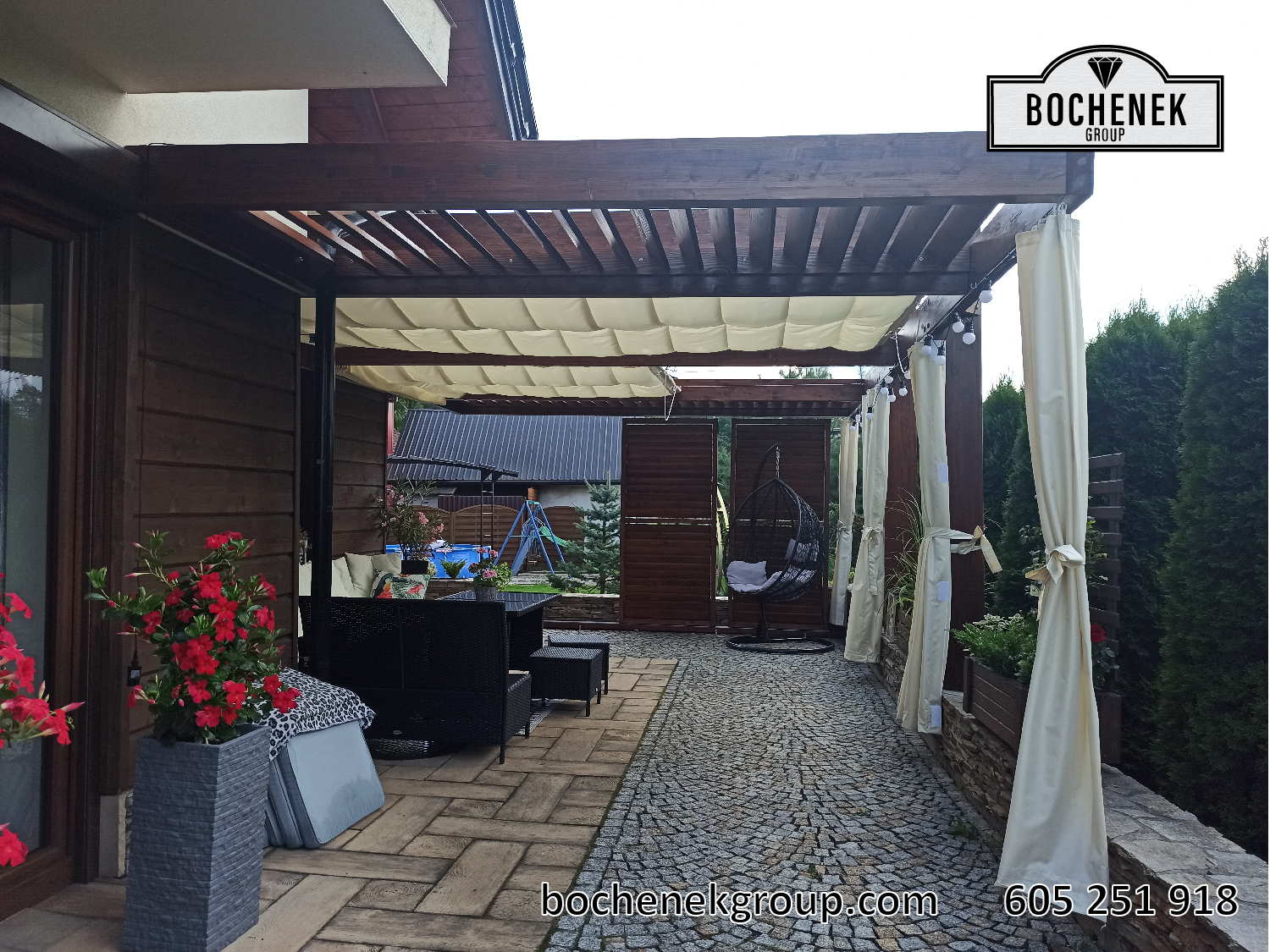 Pergola drewniana Kleopatra na tarasie z meblami ogrodowymi i trejazem z roslinami