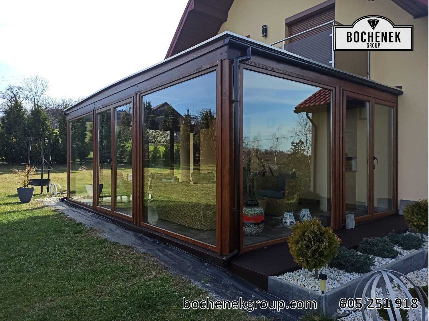 Drewniany ogród letni Artemis z duzymi oknami, ustawiony na trawniku przy domu